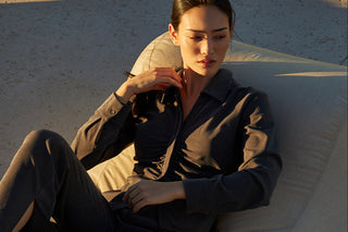 A woman wearing a ruched button up top with matching trousers.