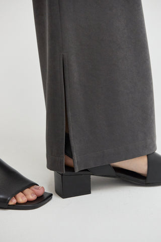 A close up of a woven trouser with a slit at the hem.