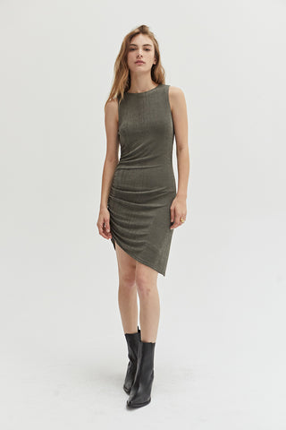 A woman wearing an asymmetrical knit mini dress with side ruching detail.