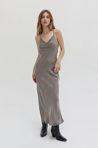 A woman wearing a cupro maxi slip dess in charcoal.