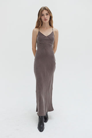 A woman wearing a cupro maxi slip dess in espresso.