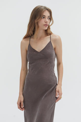 A woman wearing a cupro maxi slip dess in espresso.