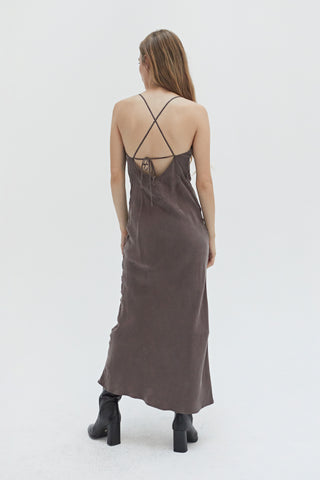 A woman wearing a cupro maxi slip dess in espresso.