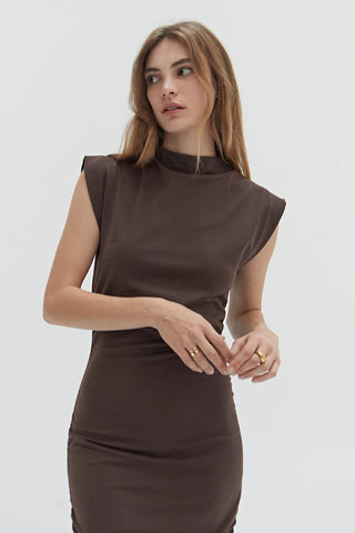 A woman wearing a mock neck midi dress with ruching at the sides. 