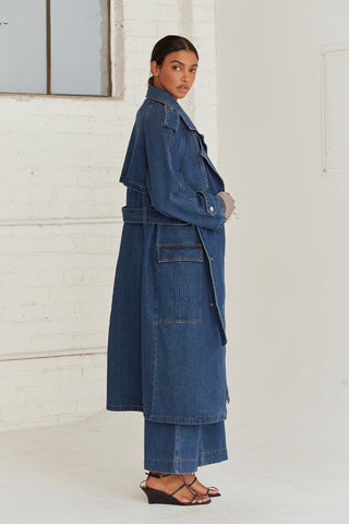 A woman wearing a denim trench coat. 