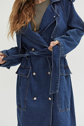 A woman wearing a denim trench coat. 