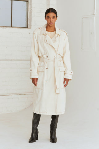 A woman wearing a cream denim trench coat.