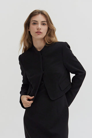 A woman wearing a tencel wool blend cropped blazer with two hidden button front closure.