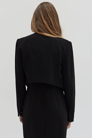 A woman wearing a tencel wool blend cropped blazer with two hidden button front closure.