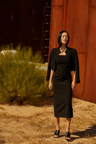 A woman wearing a tencel wool blend cropped blazer with two hidden button front closure.