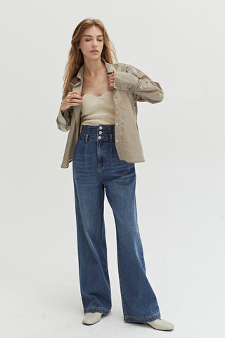 A woman wearing a high waisted denim pants with straight leg and side pockets. 