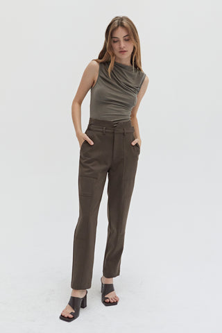 A woman wearing a high waisted seam detailed pants. 