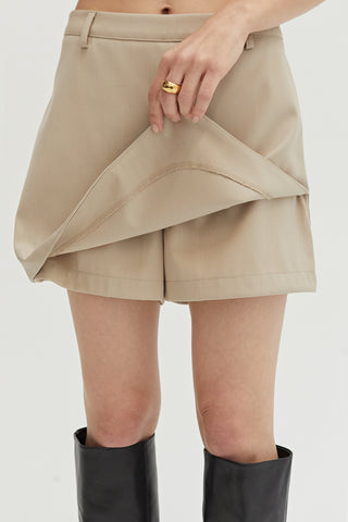 A woman wearing a bone mini skort with elasticized back waistband.