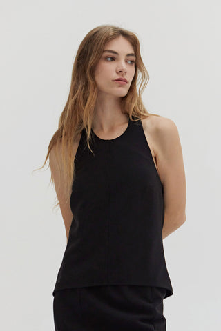 A woman wearing a tencel wool blend halter top with front seam detail. 