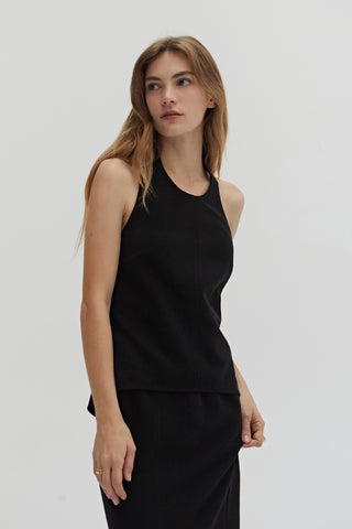 A woman wearing a tencel wool blend halter top with front seam detail. 